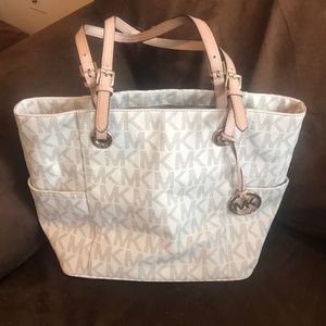 Cream colored MK purse with tan straps.